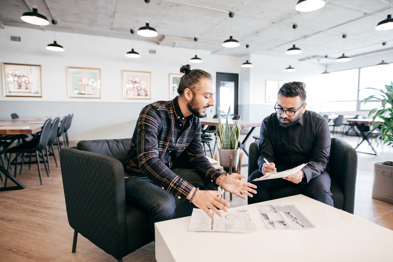 Two businessmen in an office planning for their business' B2B sales strategies.