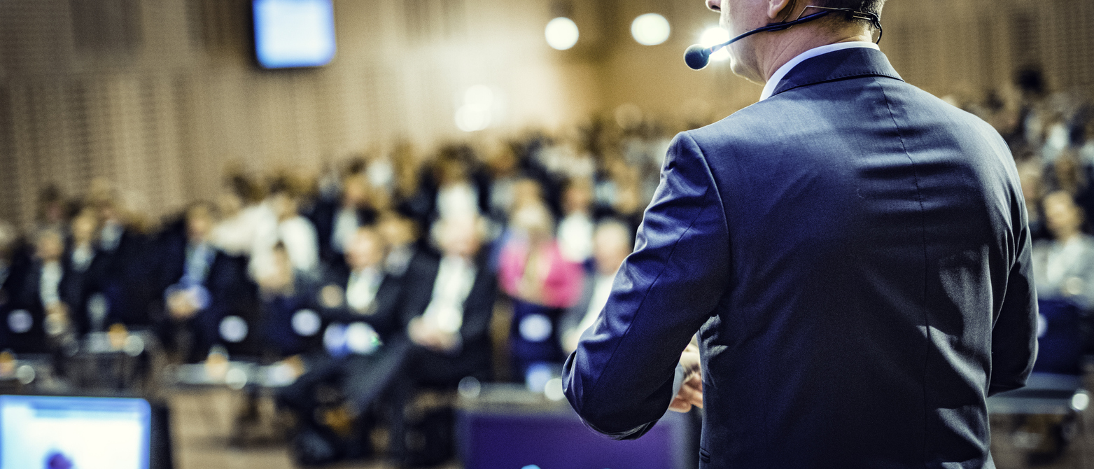 Male coach conducting CEO coaching to a group of executives in a conference room.