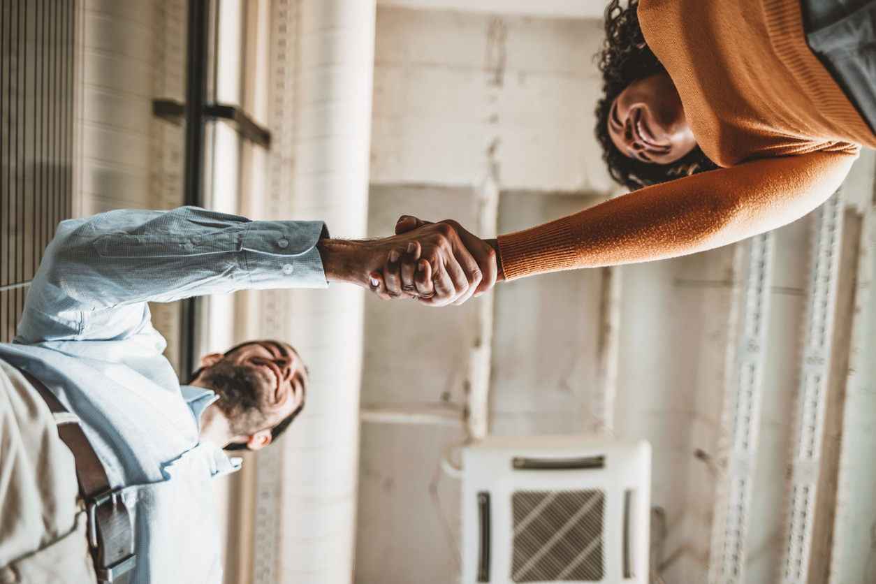 Two business people shaking hands after setting business goals.