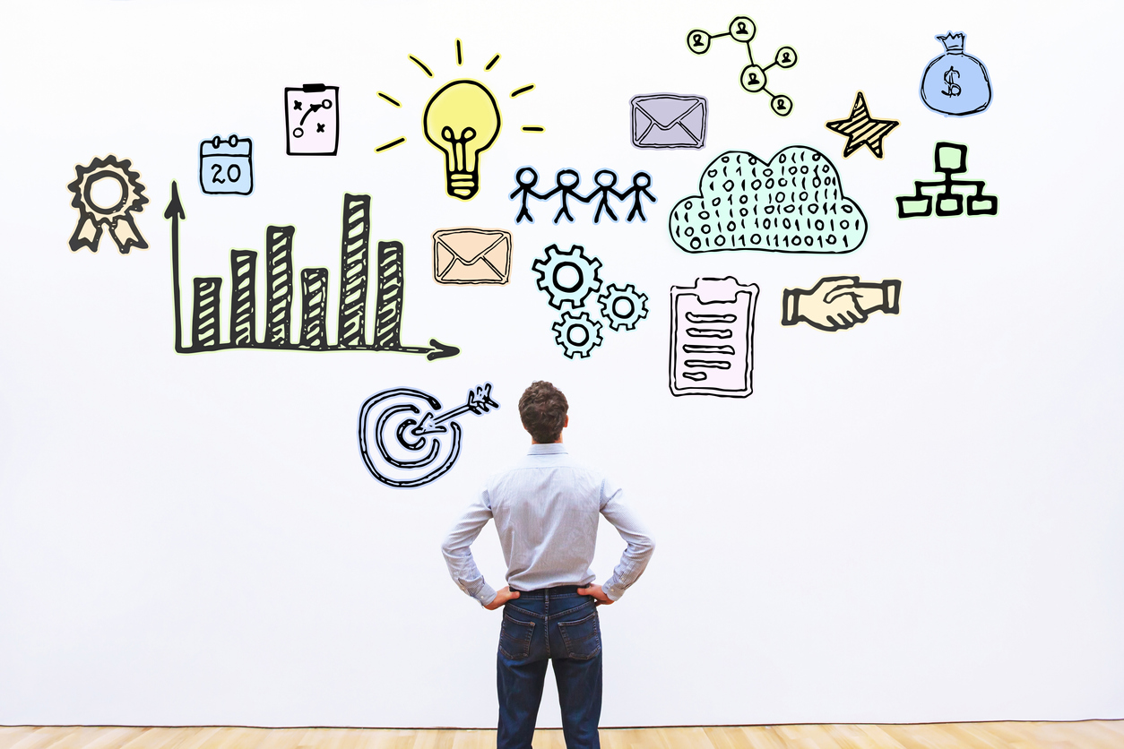 Businessman looking at an illustration of different business concepts.