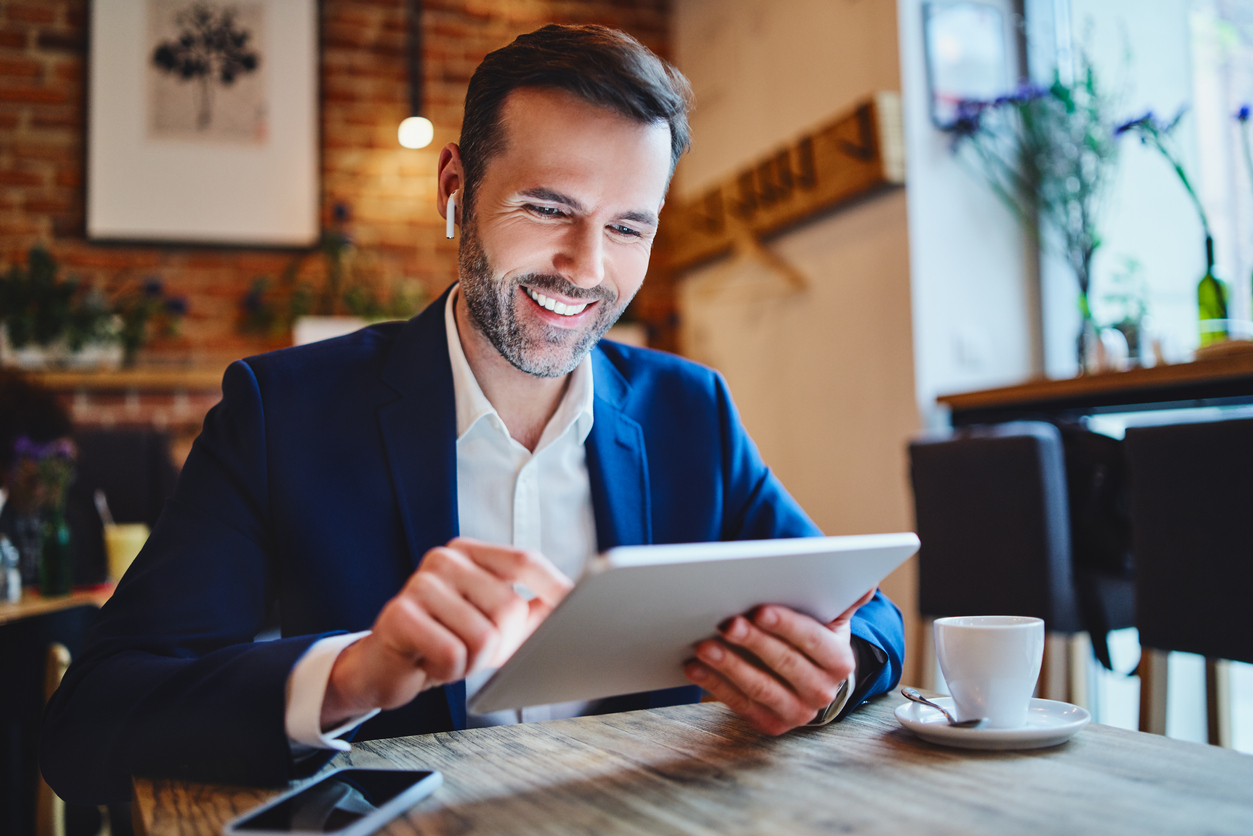 Businessman using a tablet device to reach out to his prospects and manage their business needs.