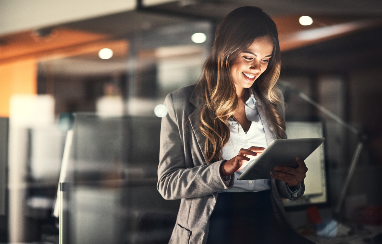 Businesswoman in an office holding a tablet device to review her company's business processes.